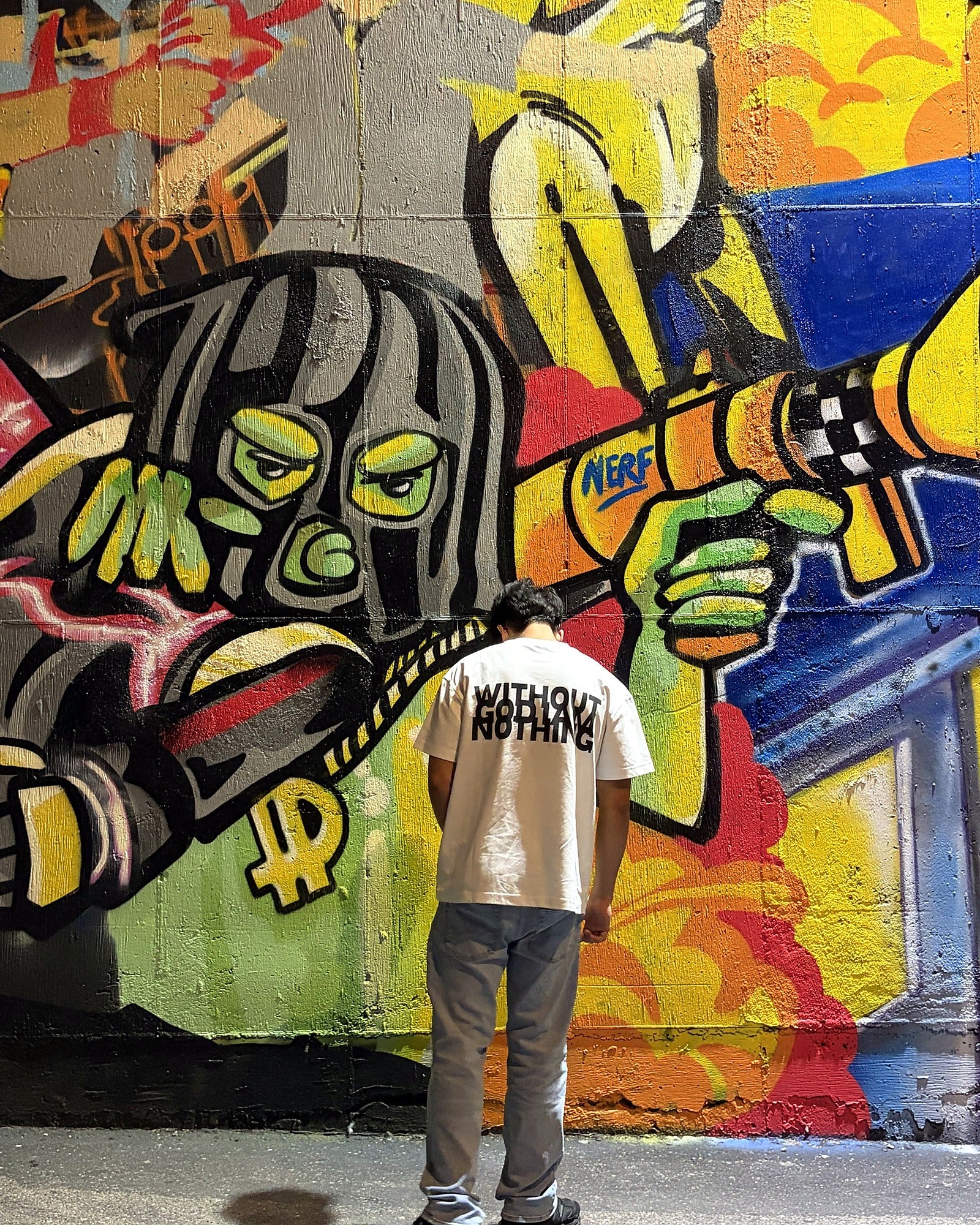 Model in FPD shirt in front of graffiti wall